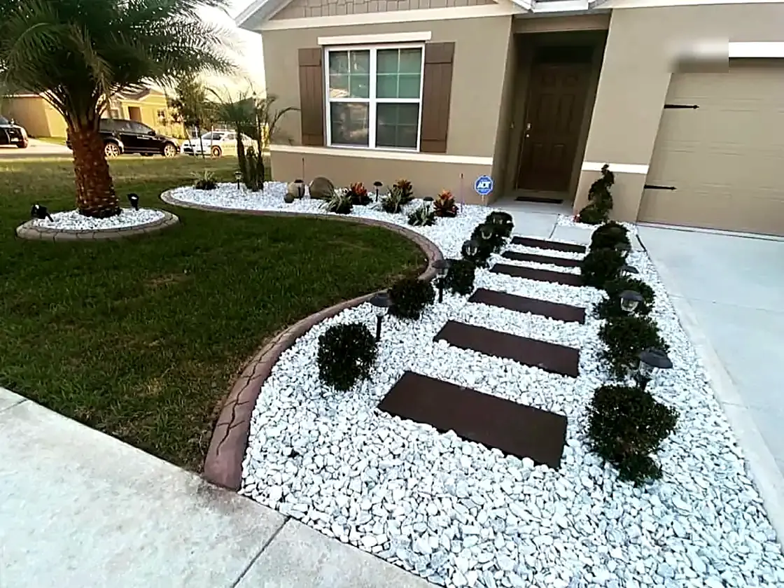 White rock, pavers, and trimmed shrubs